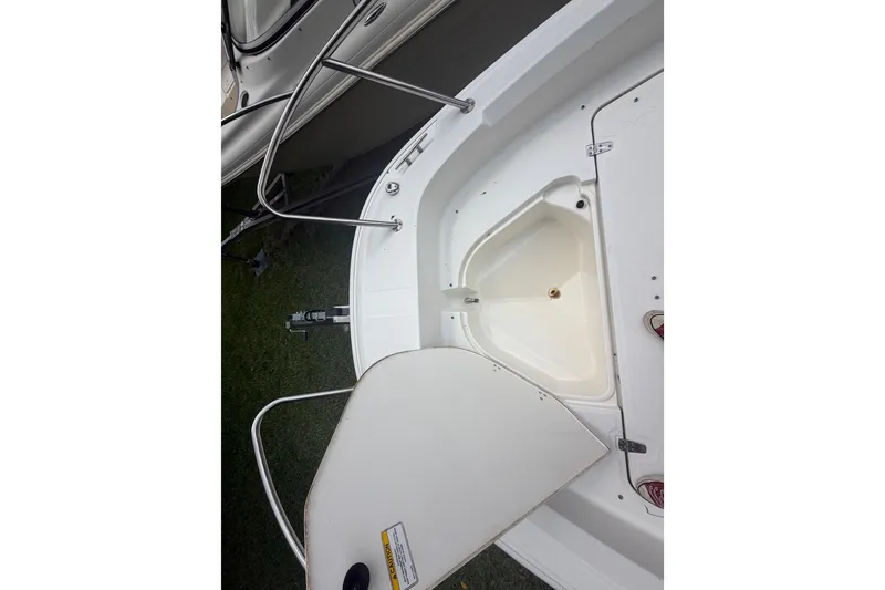 Slide: The Image of 2019 Boston Whaler 210 Dauntless boat interior showing storage compartment and railing. - 24
