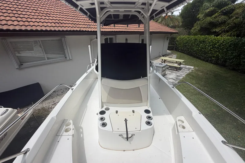 Slide: The Image of 2019 Boston Whaler 210 Dauntless boat with center console, docked near a house. - 25
