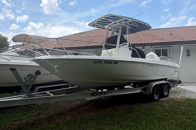 Slide: The Image of 2019 Boston Whaler 210 Dauntless boat on trailer, parked outdoors. - 6