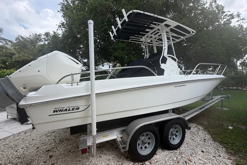 Slide: The Image of 2019 Boston Whaler 210 Dauntless boat on trailer, parked outdoors. - 9