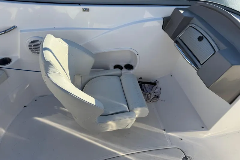 Slide: The Image of 2009 Hurricane SunDeck 210 IO boat interior with white captain's chair and dashboard. - 12