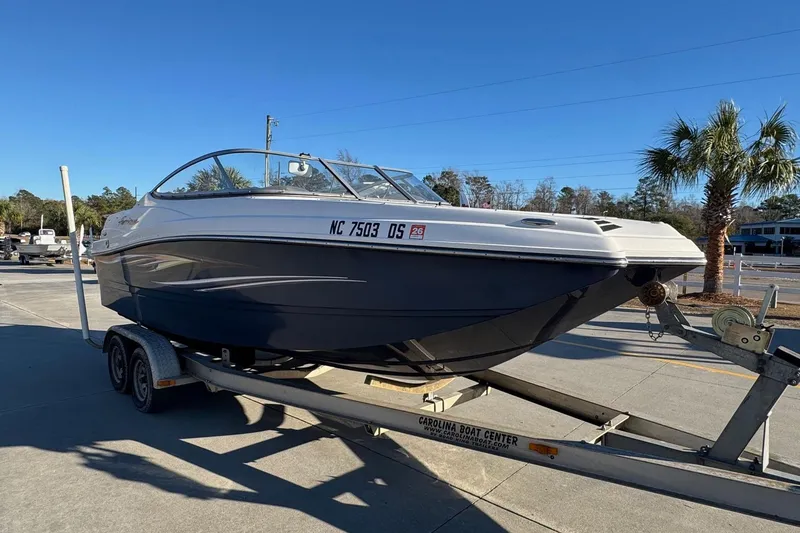 Slide: The Image of 2009 Hurricane SunDeck 210 IO boat on trailer in sunny outdoor setting. - 5