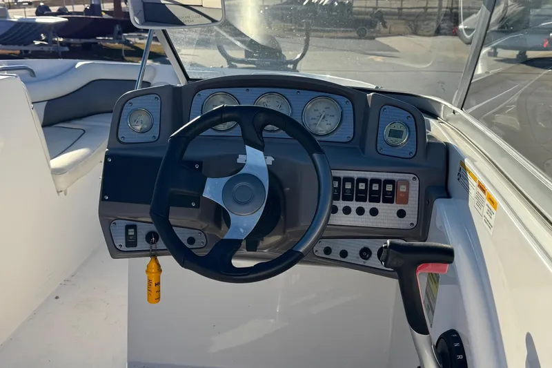 Slide: The Image of 2009 Hurricane SunDeck 210 IO boat dashboard with steering wheel and control panel. - 7