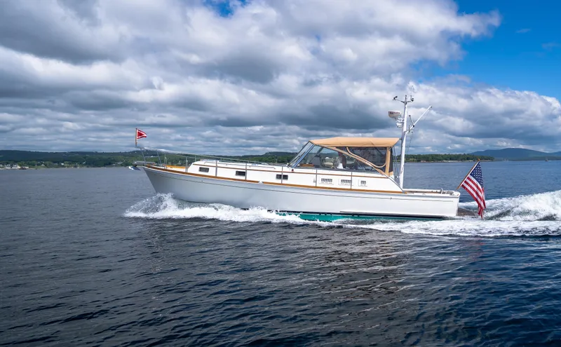 Slide: The Image of Grand Banks Eastbay 43 Ex 2000 cruising on a lake under a partly cloudy sky. - 17