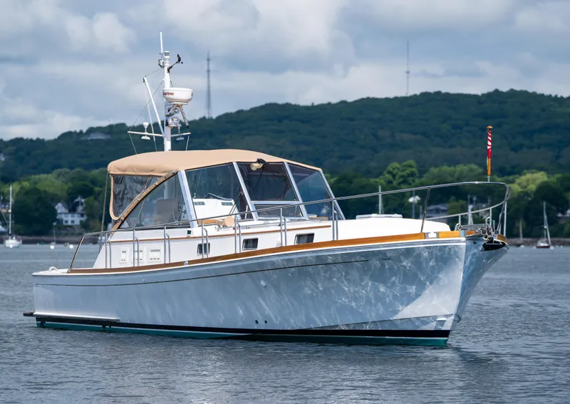 Slide: The Image of 2000 Grand Banks Eastbay 43 Ex yacht on calm water with scenic background. - 2