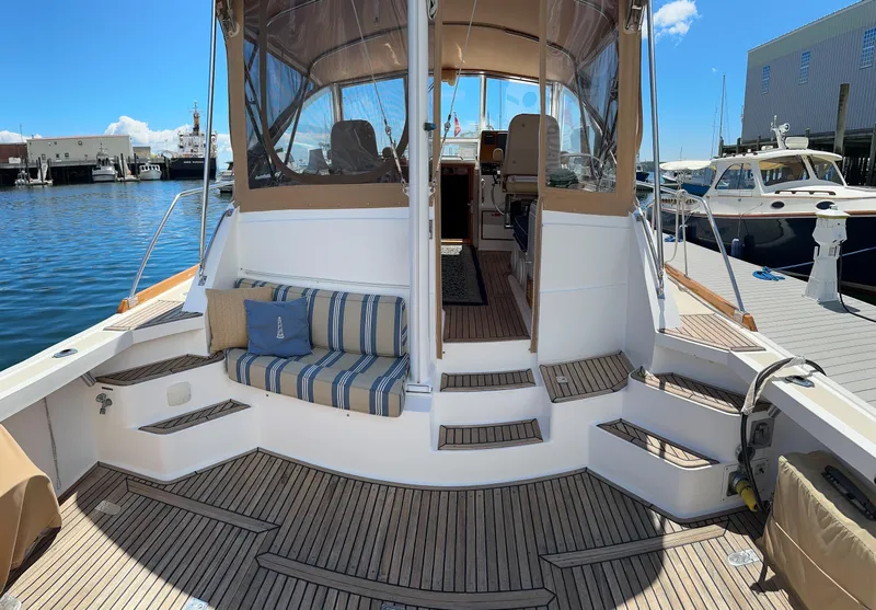 Slide: The Image of Grand Banks Eastbay 43 Ex 2000 yacht with teak deck and striped seating at marina. - 24