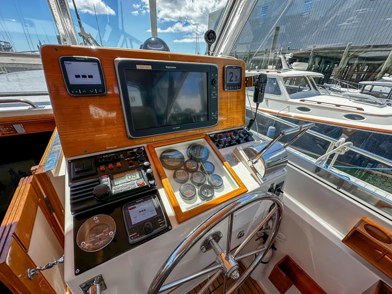 Slide: The Image of Helm station of 2000 Grand Banks Eastbay 43 Ex with navigation equipment and steering wheel. - 33