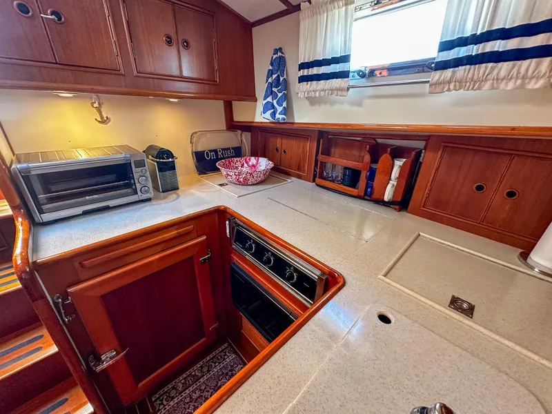 Slide: The Image of 2000 Grand Banks Eastbay 43 Ex galley with wooden cabinets and modern appliances. - 45