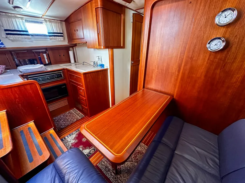 Slide: The Image of Interior of 2000 Grand Banks Eastbay 43 Ex yacht with wooden cabinetry and cozy seating area. - 48