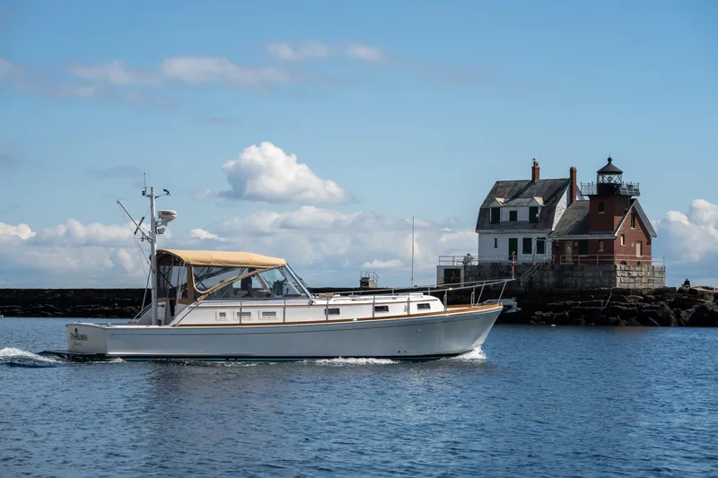 Slide: The Image of Grand Banks Eastbay 43 Ex 2000 cruising near a coastal lighthouse. - 6