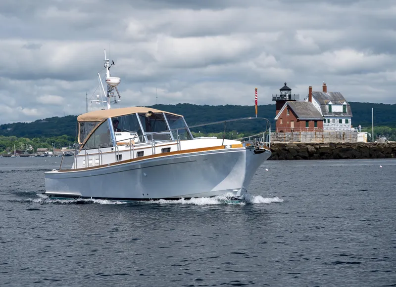 Slide: The Image of Grand Banks Eastbay 43 Ex 2000 cruising near a coastal lighthouse. - 7