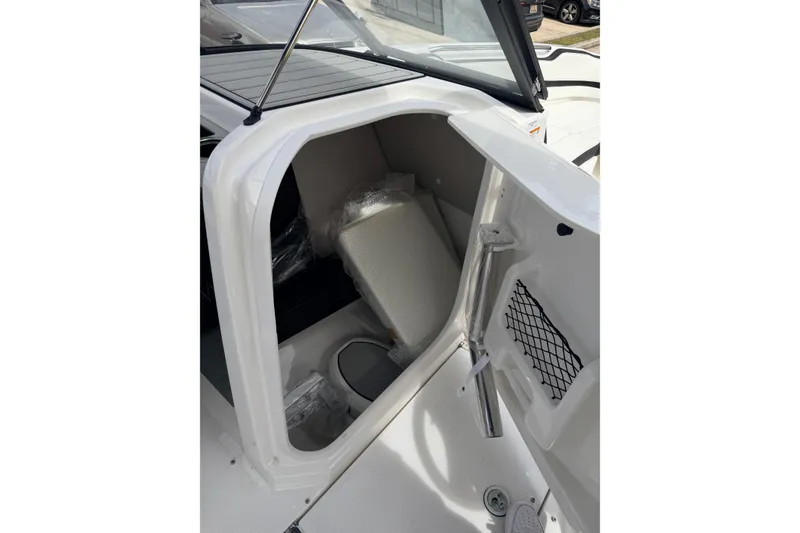 Slide: The Image of 2026 Yamaha Boats 252SD interior storage compartment with seating and netted pocket. - 21