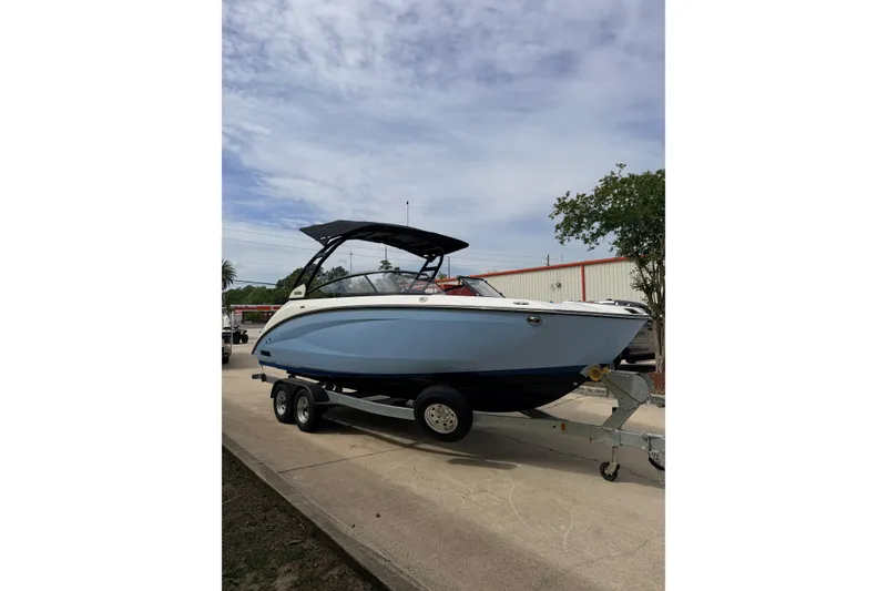 Slide: The Image of 2026 Yamaha Boats 252SD on trailer, sleek design, blue hull, parked outdoors. - 5
