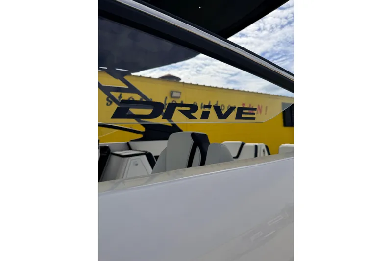 Slide: The Image of 2026 Yamaha Boats 252SD interior with "Drive" decal, yellow building background. - 9