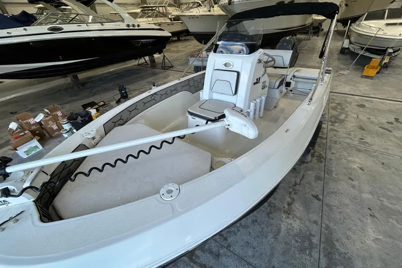 Slide: The Image of 2020 Wellcraft 162 Fisherman boat in a showroom, featuring a sleek white design. - 5