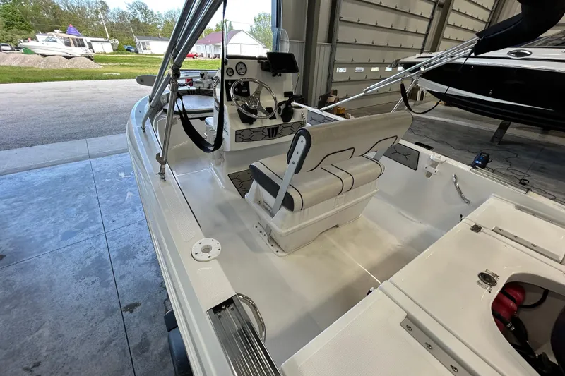 Slide: The Image of 2020 Wellcraft 162 Fisherman boat interior with steering console and seating in a garage. - 9