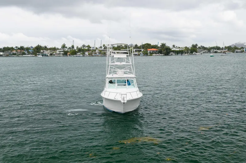 Slide: The Image of 2006 Cabo 35 Express boat cruising on a calm waterway under cloudy skies. - 11