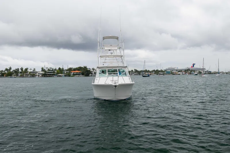 Slide: The Image of 2006 Cabo 35 Express boat on water under cloudy sky, near shoreline. - 15