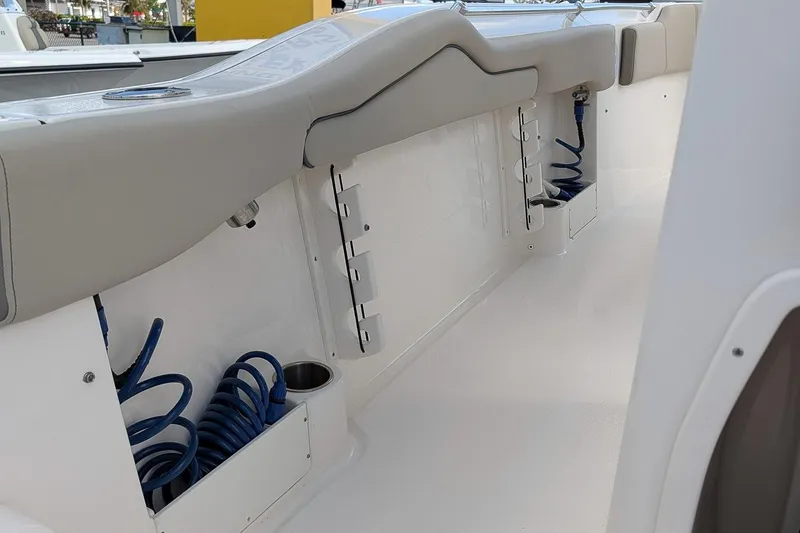 Slide: The Image of 2023 Key West 263 FS boat interior with seating and coiled hose storage. - 10