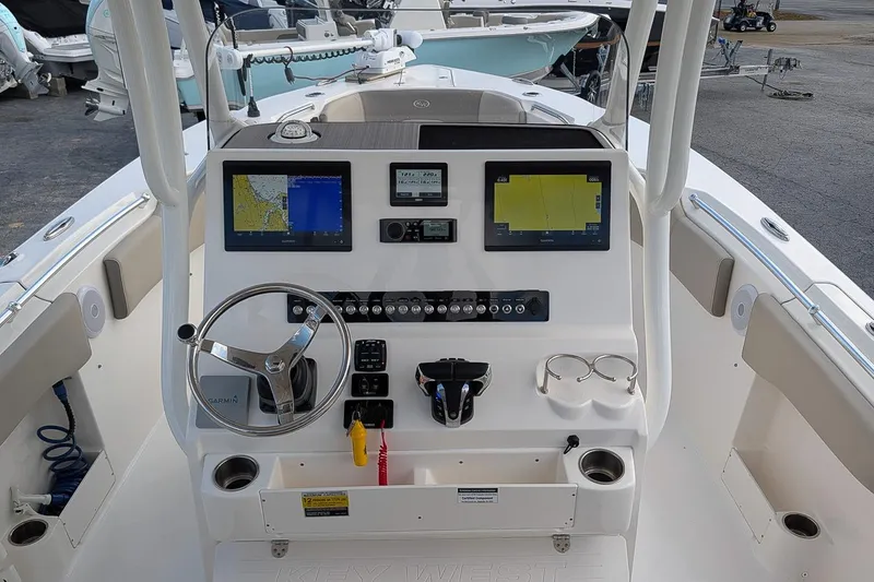 Slide: The Image of 2023 Key West 263 FS boat dashboard with navigation screens and steering wheel. - 13