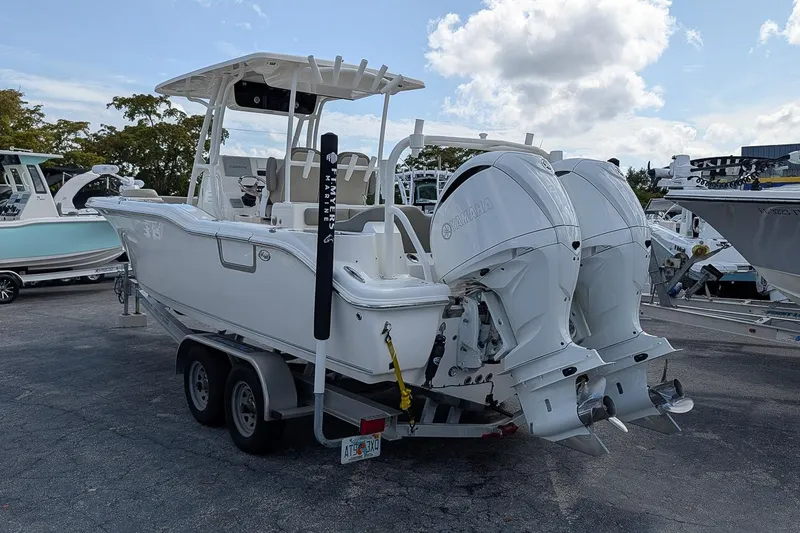 Slide: The Image of 2023 Key West 263 FS boat with dual Yamaha engines on a trailer. - 2
