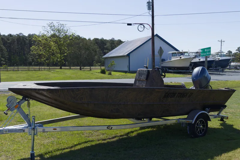 The Image of 2026 G3 Gator Tough 17 CC boat on trailer, parked outdoors near a building. - 1