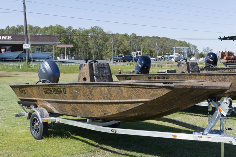 Slide: The Image of 2026 G3 Gator Tough 17 CC boat on trailer, camo design, parked outdoors. - 5