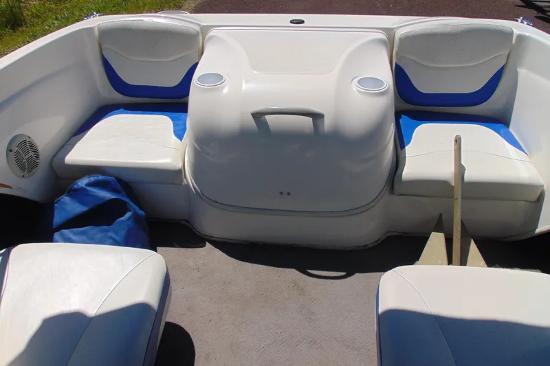 Slide: The Image of 2006 Bayliner 175 Bowrider interior with white and blue seating, cup holders, and storage space. - 10