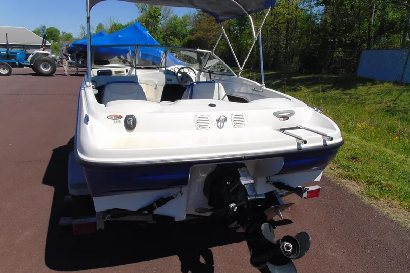 Slide: The Image of 2006 Bayliner 175 Bowrider boat with canopy, parked outdoors on a sunny day. - 4