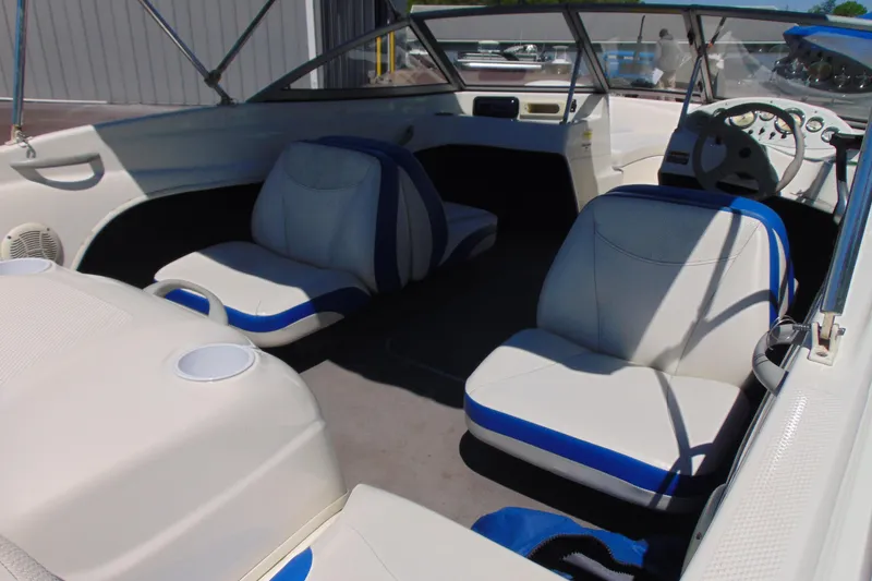 Slide: The Image of 2006 Bayliner 175 Bowrider interior with white and blue seating, steering wheel, and cup holders. - 7