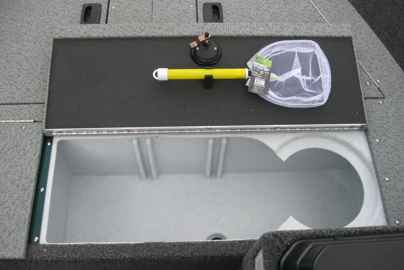 Slide: The Image of Open storage compartment on 2026 Lund 1650 Angler SS boat with fishing net and accessories. - 11