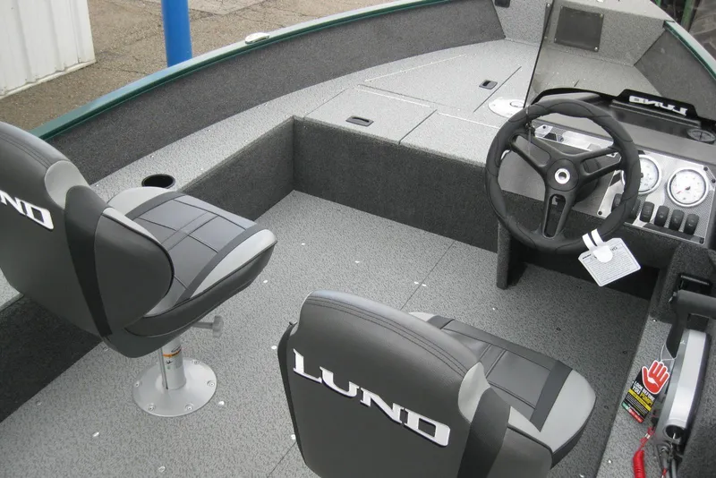 Slide: The Image of 2026 Lund 1650 Angler SS boat interior with steering wheel and seating. - 8