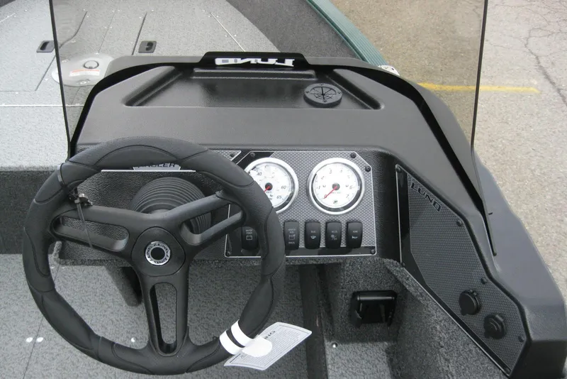 Slide: The Image of 2026 Lund 1650 Angler SS boat dashboard with steering wheel and gauges. - 9