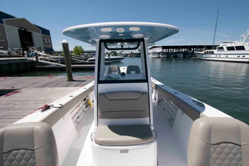 Slide: The Image of 2023 Sportsman Heritage 261 Center Console boat docked at marina, showcasing spacious seating. - 10
