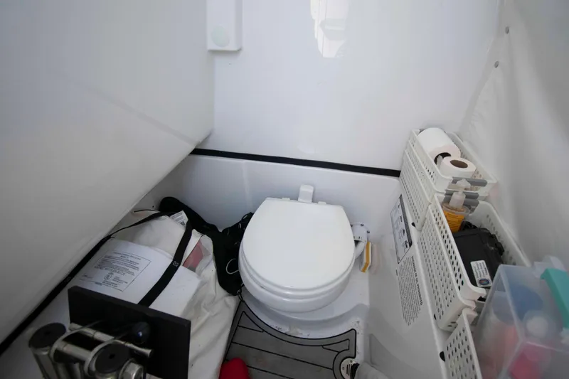 Slide: The Image of 2023 Sportsman Heritage 261 Center Console boat interior with toilet and storage compartments. - 16