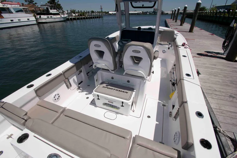 Slide: The Image of 2023 Sportsman Heritage 261 Center Console boat docked, showcasing spacious seating and modern design. - 2