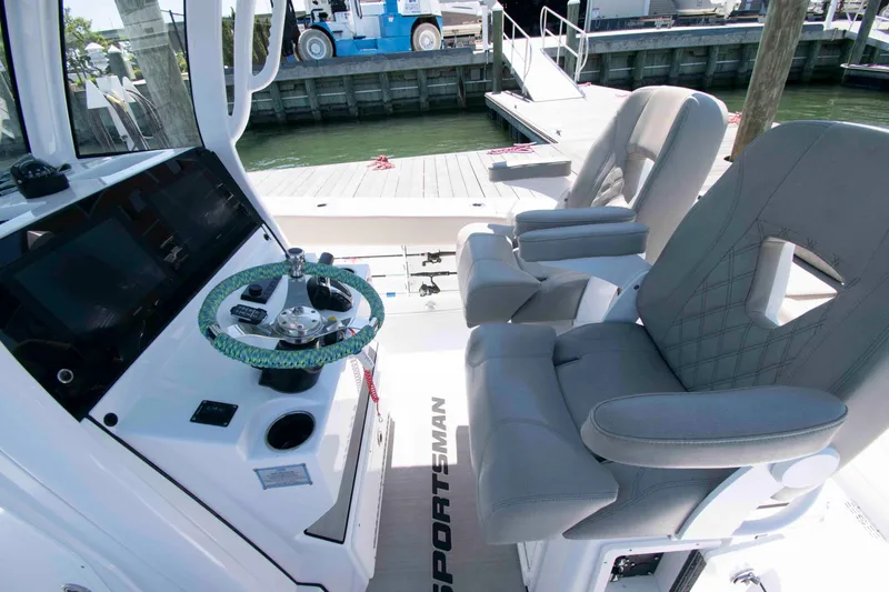 Slide: The Image of 2023 Sportsman Heritage 261 Center Console boat interior with steering wheel and cushioned seats. - 8