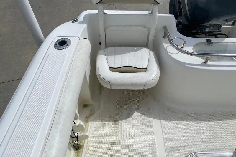 Slide: The Image of 2010 Key West 211 Center Console boat interior with seating and engine view. - 11
