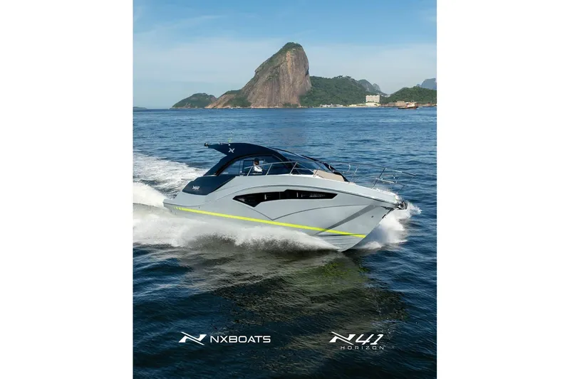 Slide: The Image of 2026 NX Boats NX41 HORIZON cruising on scenic waters with mountainous backdrop. - 24