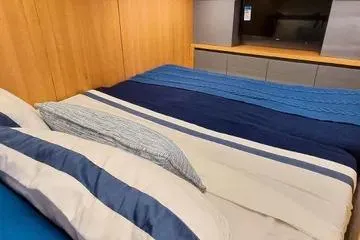 Slide: The Image of Luxurious bedroom interior of 2026 NX Boats NX41 HORIZON with striped bedding. - 7