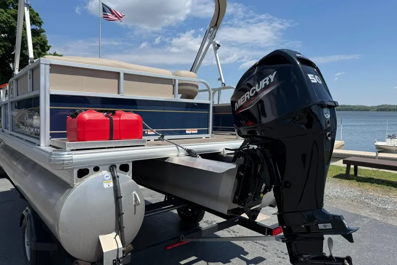 Slide: The Image of 2023 Sun Tracker Bass Buggy 16 XL Select pontoon boat with Mercury 50 engine by a lake. - 3