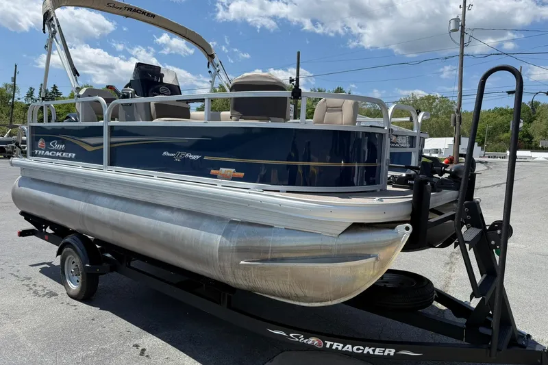 Slide: The Image of 2023 Sun Tracker Bass Buggy 16 XL Select pontoon boat on trailer, outdoors. - 6