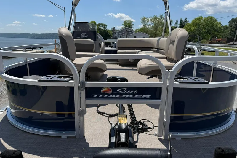 Slide: The Image of 2023 Sun Tracker Bass Buggy 16 XL Select pontoon boat docked by a scenic lake. - 7