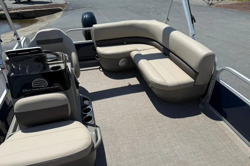 Slide: The Image of 2023 Sun Tracker Bass Buggy 16 XL Select pontoon boat interior with beige seating. - 9