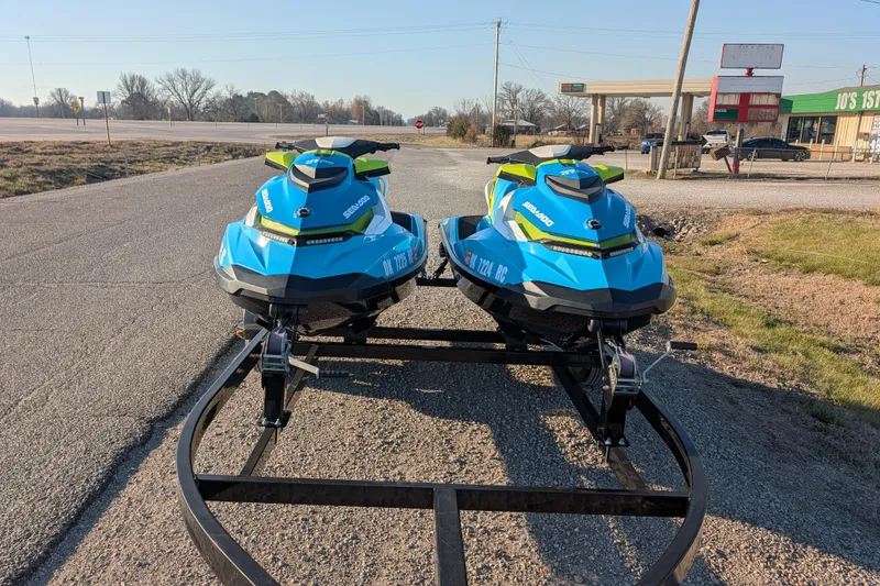 Slide: The Image of Two blue 2016 Sea-Doo GTI SE 130 jet skis on a trailer in a rural setting. - 15