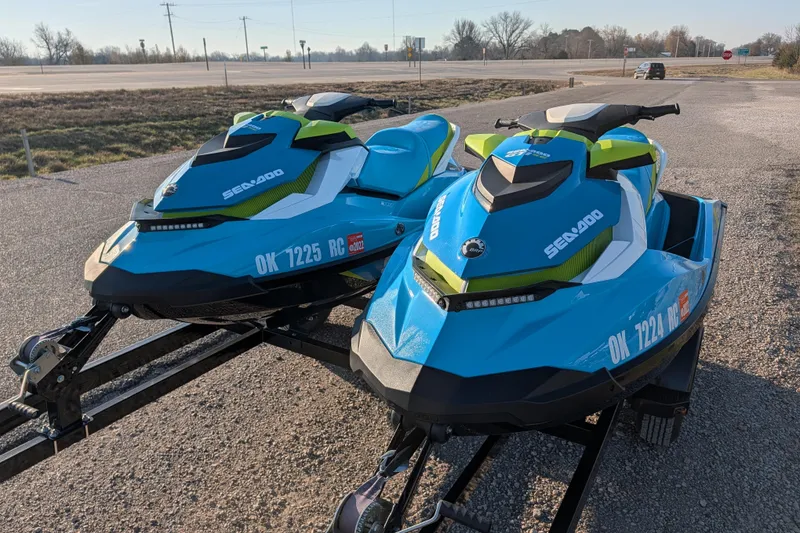 Slide: The Image of Two 2016 Sea-Doo GTI SE 130 jet skis on a trailer in a parking area. - 4