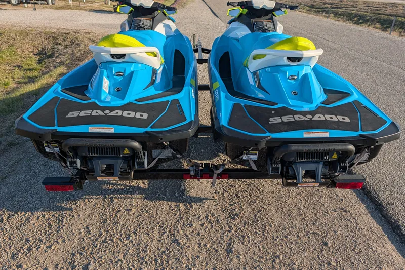 Slide: The Image of Two blue 2016 Sea-Doo GTI SE 130 jet skis on a trailer, parked on a road. - 8
