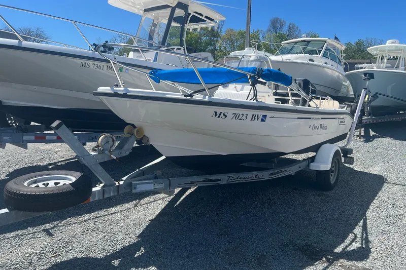 Slide: The Image of 2007 Boston Whaler 160 Dauntless boat on trailer, parked among other boats. - 2