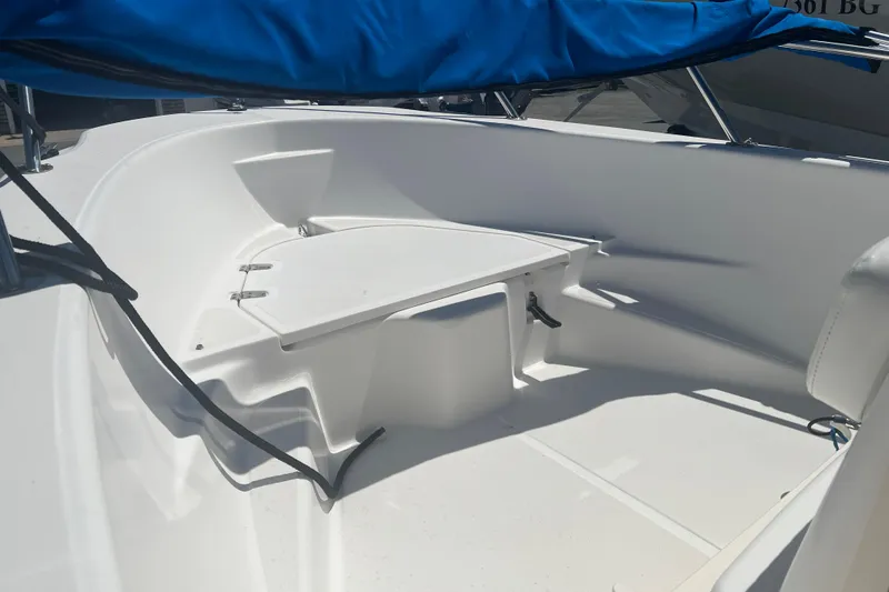 Slide: The Image of 2007 Boston Whaler 160 Dauntless boat interior with blue cover, showcasing seating and storage. - 3