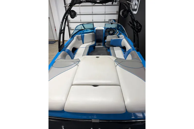 Slide: The Image of 2016 Sanger V237 S boat interior with blue and gray seating in a garage. - 10